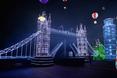 Park rozrywki z architekturą w tle: krzywa wieża i London Bridge 