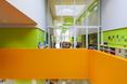 W wysokich wnętrzach bryły dominuje jaskrawa pomarańcz i zieleń - multifunkcjonalna architektura współczesna The Klarendal w miejscowości Arnhem w Holandii  autor: pracownia architektoniczna DeZwarteH