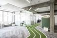 Pas zieleni ciągnie się przez całą przestrzeń biura - architektura wnętrz dla siedziby biura Onefootball w Berlinie