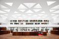 Drewniana podłoga kontrastuje z ażurowym sufitem z trójkątnych otworów  autor: holenderska pracownia KAAN Architecten