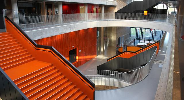 Szkoła w Larvik. Przestronne korytarze, pomarańczowe schody i ściany oraz szklane ściany, wszystko po to aby uczniowie poczuli się wspólnotą